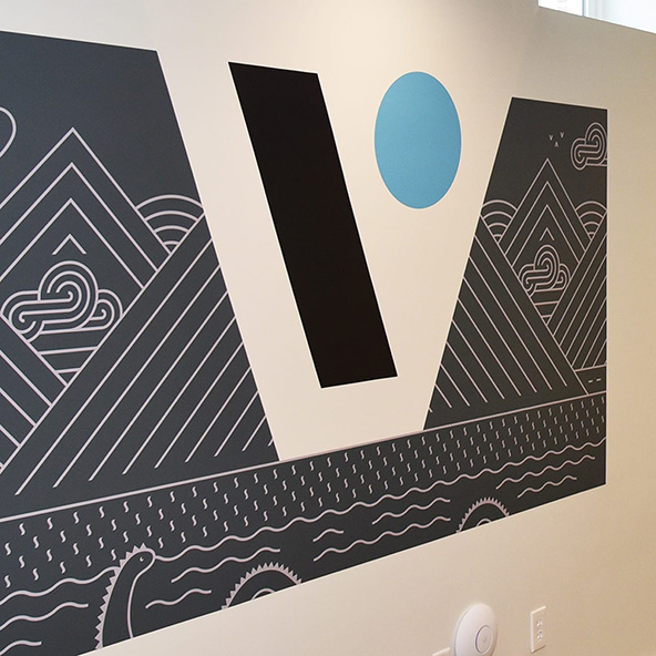 Photo of the Vitamin logo printed with playful geometric patterns on a wall.